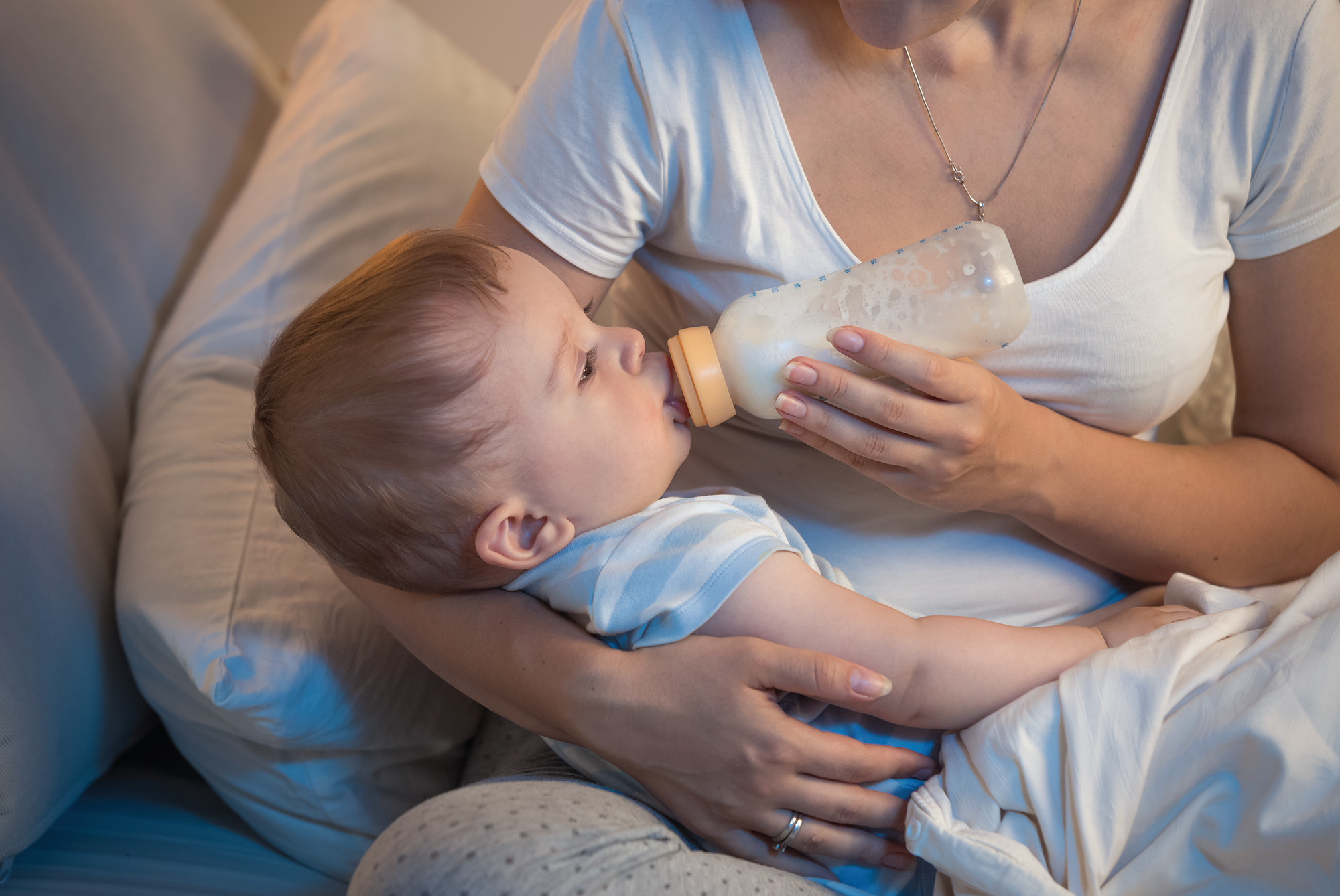 mother feeding baby with bottle.